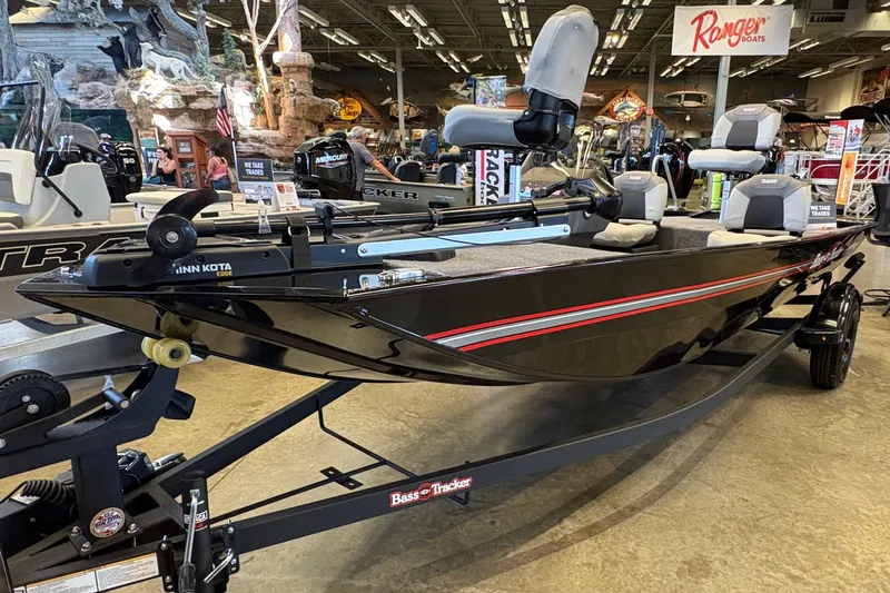 The Image of 2027 Tracker Bass Tracker Classic XL boat displayed in showroom with seating and trolling motor. - 0