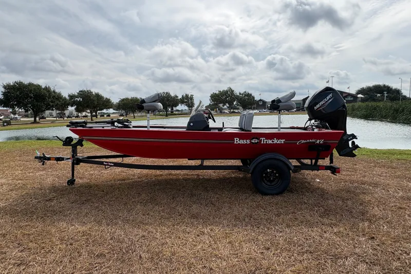 Slide: The Image of 2027 Tracker Bass Tracker Classic XL boat on trailer by a lake. - 75