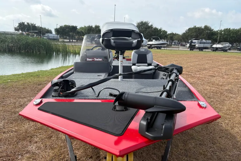 Slide: The Image of 2027 Tracker Bass Tracker Classic XL boat on grassy shore near water. - 73