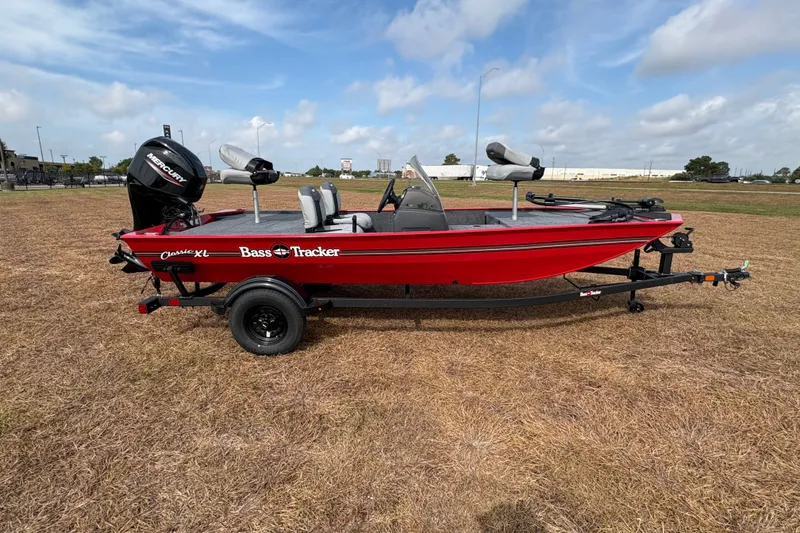 Slide: The Image of 2027 Tracker Bass Tracker Classic XL boat on trailer, red exterior, parked on grass. - 79