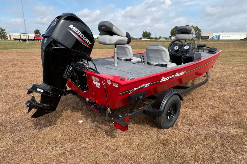 Slide: The Image of 2027 Tracker Bass Tracker Classic XL boat with Mercury engine on grassy field. - 78