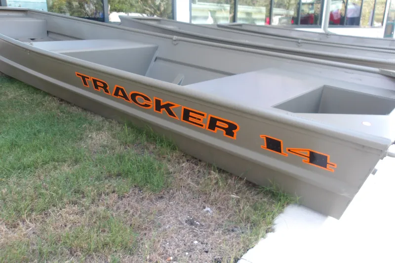 The Image of 2027 Tracker Grizzly 14 Jon boat on grass, showcasing bold orange lettering. - 0