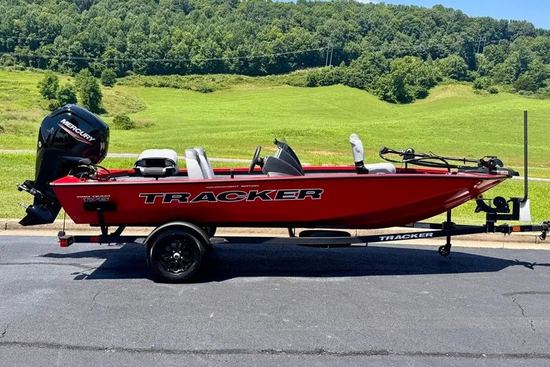 The Image of 2027 Tracker Pro Team 175 boat on trailer, red color, parked outdoors. - 0