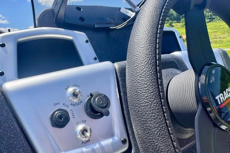 Slide: The Image of Steering console of 2027 Tracker Pro Team 175 boat with control switches and steering wheel. - 15