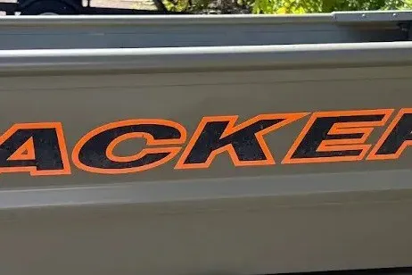 The Image of 2027 Tracker Grizzly 14 Jon boat with bold orange lettering. - 0