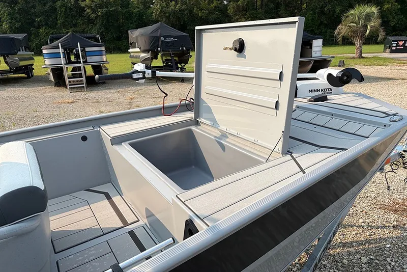 Slide: The Image of 2027 Tracker Bass Tracker Classic CC boat with open storage compartment, parked outdoors. - 13