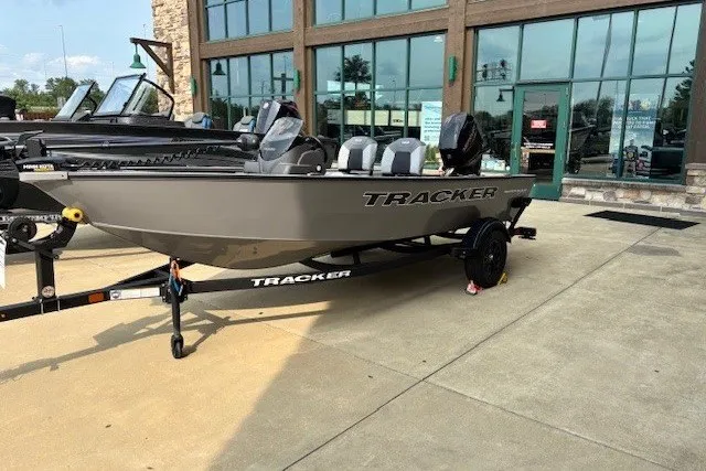 The Image of 2027 Tracker Super Guide V-16 SC boat displayed outside a showroom on a trailer. - 0