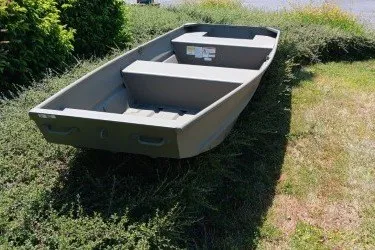 The Image of 2027 Tracker Grizzly 14 Jon boat on grass, showcasing durable design and spacious interior. - 0