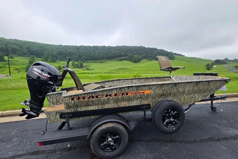 The Image of 2027 Tracker Grizzly 1553 Timber boat on trailer, camo design, Mercury outboard motor. - 0