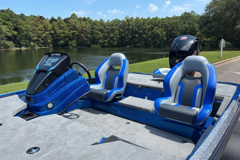 Slide: The Image of 2027 Nitro Z18 XL boat with blue seats by a serene lake. - 5