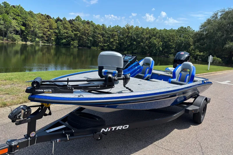 Slide: The Image of 2027 Nitro Z18 XL boat with Minn Kota motor by a scenic lake. - 2
