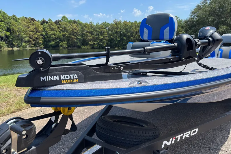 Slide: The Image of 2027 Nitro Z18 XL boat with Minn Kota Maxxum trolling motor by a scenic lake. - 6