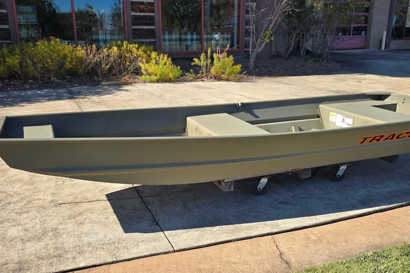 The Image of 2027 Tracker Grizzly 14 Jon boat displayed outdoors on a sunny day. - 0