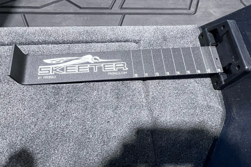 Slide: The Image of Skeeter FXR20 2026 boat ruler on carpeted surface, featuring measurement markings. - 9