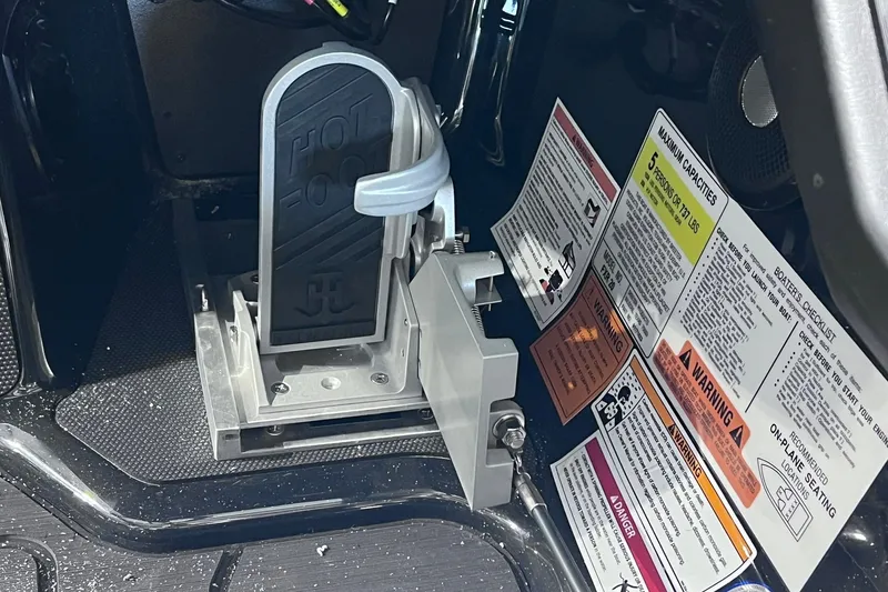 Slide: The Image of Foot pedal and safety labels in a 2026 Skeeter FXR20 boat cockpit. - 13