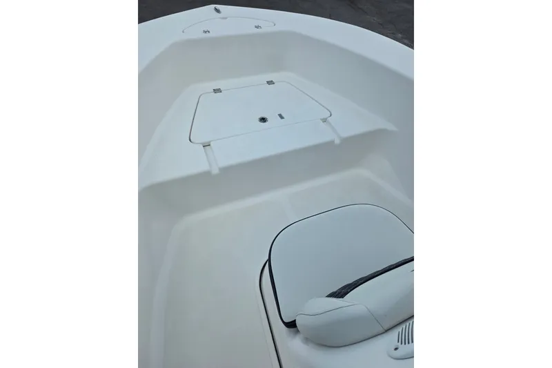Slide: The Image of 2024 Tidewater 180 CC Adventure boat interior, featuring sleek white seating and storage compartment. - 9