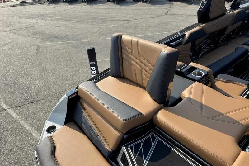 Slide: The Image of 2027 Tigé 25ZX boat interior with tan and black seating, cup holder, and sleek design. - 10