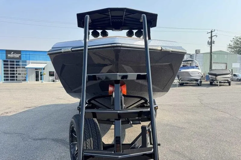 Slide: The Image of 2027 Tigé 25ZX boat on trailer, front view at dealership lot. - 11