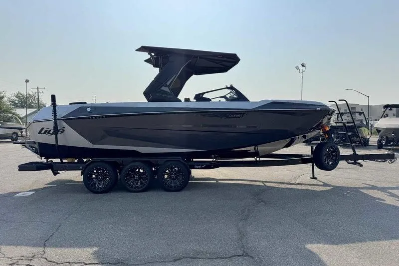 Slide: The Image of 2027 Tigé 25ZX boat on trailer, sleek design, parked outdoors. - 15
