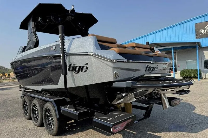 Slide: The Image of 2027 Tigé 25ZX boat on trailer, sleek design, parked outside blue building. - 7