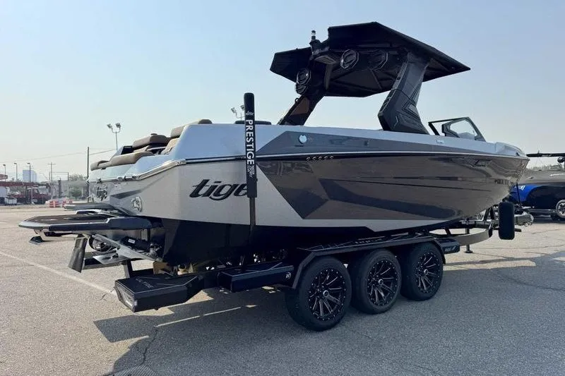 Slide: The Image of 2027 Tigé 25ZX boat on trailer, sleek design, parked outdoors. - 12