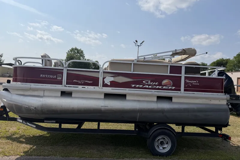 The Image of 2018 Sun Tracker Bass Buggy 18 DLX pontoon boat on trailer, parked outdoors. - 0