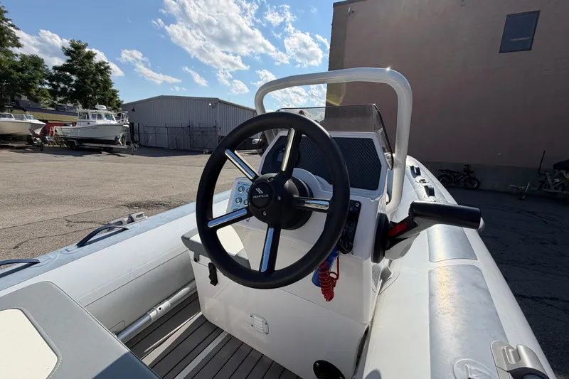 Slide: The Image of 2025 Highfield Classic 380 FCT boat steering console in a marina setting. - 9