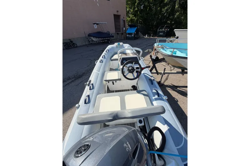 Slide: The Image of 2025 Highfield Classic 380 FCT inflatable boat with steering console, parked outdoors. - 1