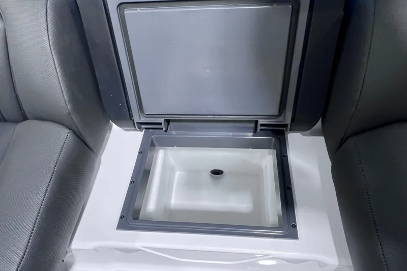 Slide: The Image of Open storage compartment in 2026 Skeeter ZXR20 SE boat, between two seats. - 11
