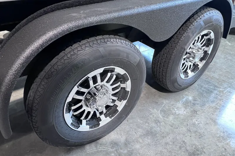 Slide: The Image of Dual wheels of a 2026 Skeeter ZXR20 SE trailer on a polished concrete floor. - 18