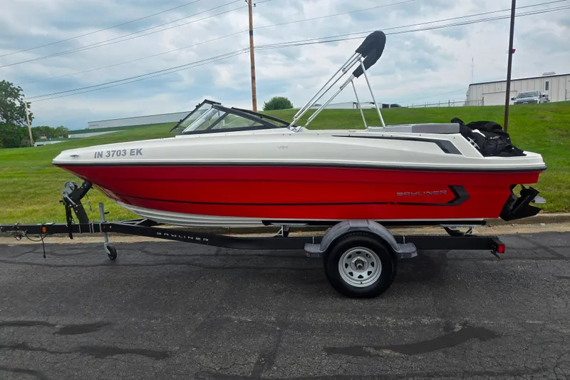 Slide: The Image of 2022 Bayliner VR4 Bowrider I/O in red on trailer, parked outdoors. - 4