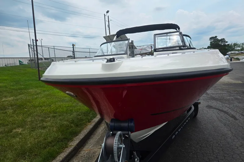 Slide: The Image of 2022 Bayliner VR4 Bowrider I/O in red, parked on a trailer, outdoor setting. - 6