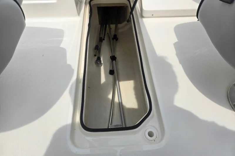 Slide: The Image of 2022 Bayliner VR4 Bowrider I/O storage compartment with visible cables and clean interior. - 12