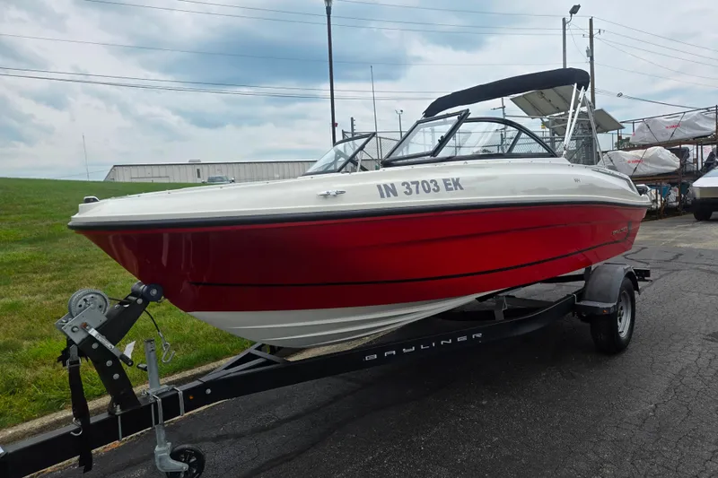 Slide: The Image of 2022 Bayliner VR4 Bowrider I/O in red on trailer, parked outdoors. - 5