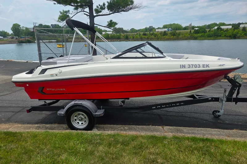 Slide: The Image of 2022 Bayliner VR4 Bowrider I/O boat on trailer by a lakeside. - 9
