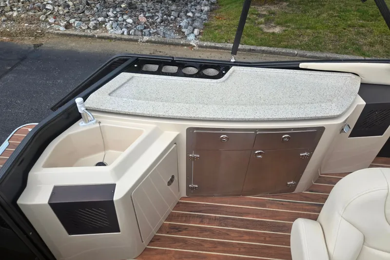 Slide: The Image of 2016 Crest Classic 230 Chateau boat interior with sink and storage cabinets. - 19