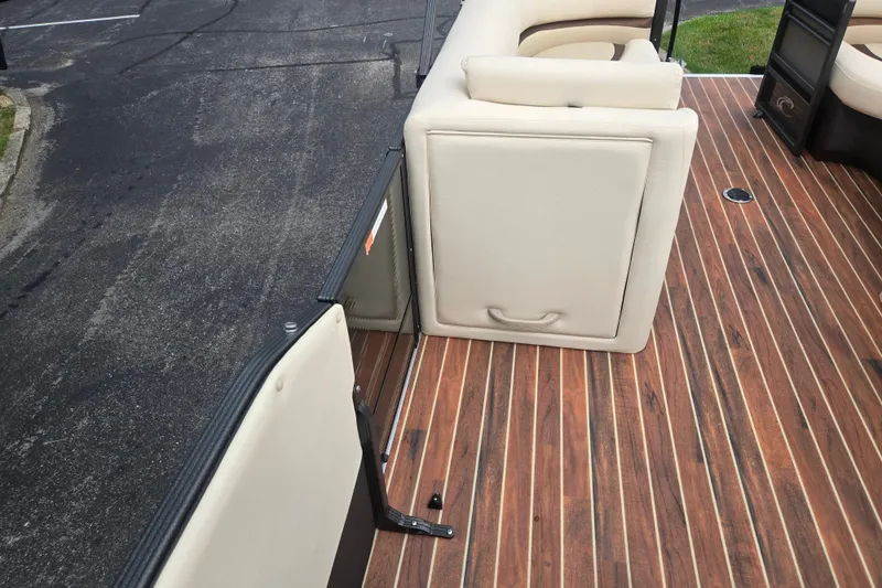 Slide: The Image of 2016 Crest Classic 230 Chateau boat interior with wood flooring and beige seating. - 22