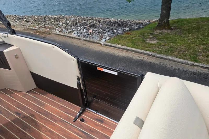 Slide: The Image of 2016 Crest Classic 230 Chateau boat interior with wood flooring, near a lakeside view. - 13