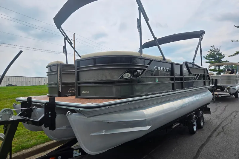 Slide: The Image of 2016 Crest Classic 230 Chateau pontoon boat on trailer, parked outdoors. - 5