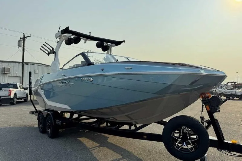 Slide: The Image of 2027 Supra R225 boat on trailer in parking lot, showcasing sleek design and modern features. - 11