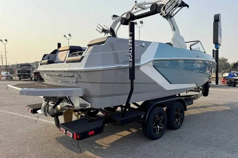 Slide: The Image of 2027 Supra R225 boat on trailer in parking lot, showcasing sleek design and modern features. - 14