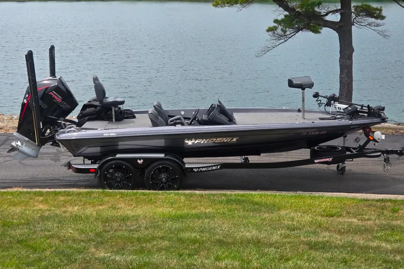 The Image of 2021 Phoenix 920 Elite boat parked by a lake, showcasing sleek design and powerful engine. - 0