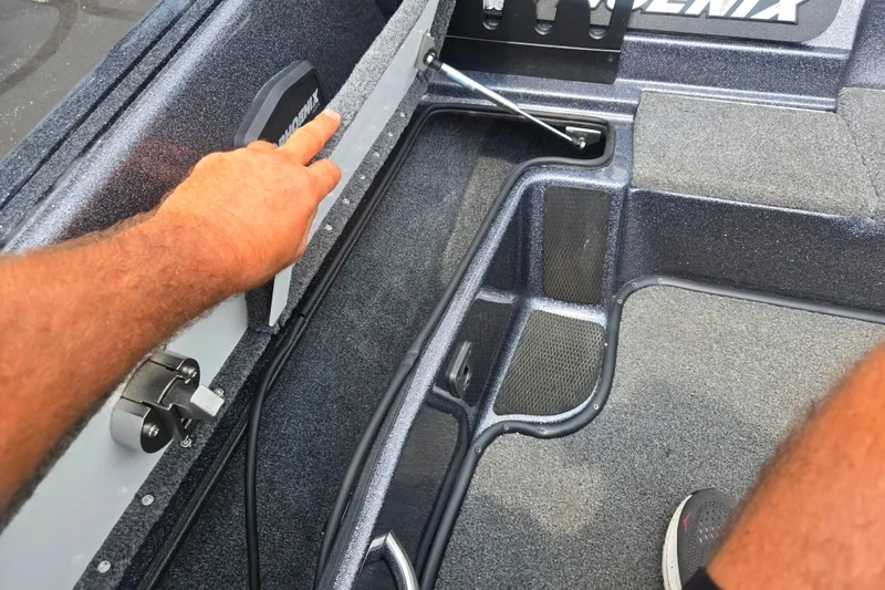 Slide: The Image of Interior view of a 2021 Phoenix 920 Elite boat, showcasing storage compartments and carpeted flooring. - 16