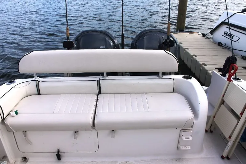 Slide: The Image of 2006 Robalo R265 Walkaround boat with white seating and fishing rods by the dock. - 14