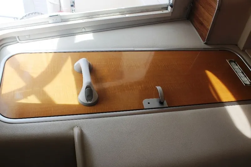 Slide: The Image of 2006 Robalo R265 Walkaround cabin interior with wooden hatch and handle. - 20