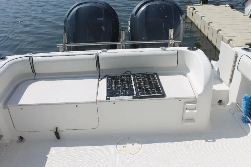 Slide: The Image of 2006 Robalo R265 Walkaround boat deck with twin engines and solar panels. - 24