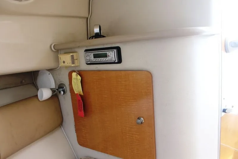 Slide: The Image of Interior of 2006 Robalo R265 Walkaround boat with radio and wooden cabinet. - 18