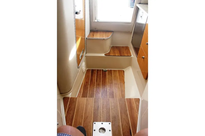Slide: The Image of 2006 Robalo R265 Walkaround cabin interior with wooden flooring and steps. - 10