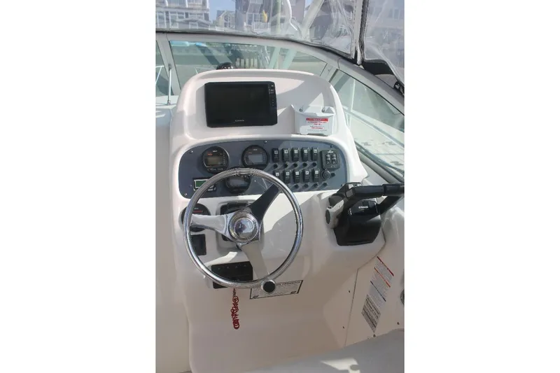 Slide: The Image of 2006 Robalo R265 Walkaround boat helm with steering wheel and control panel. - 9