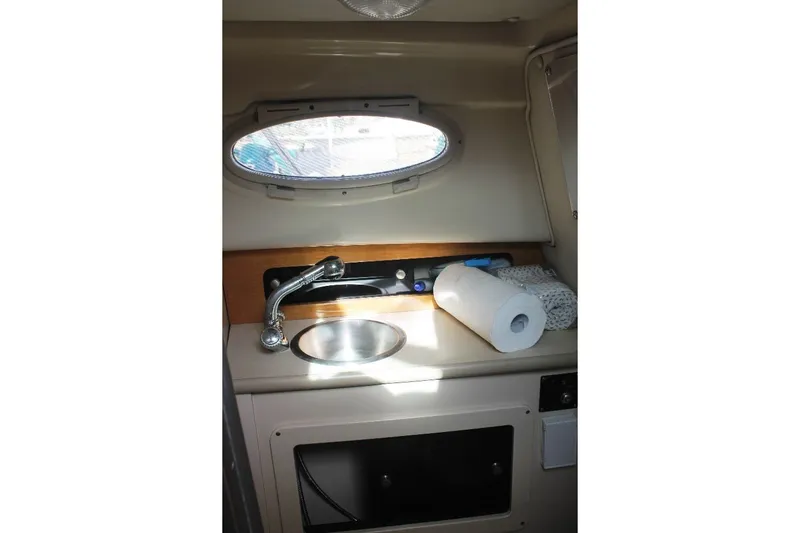 Slide: The Image of 2006 Robalo R265 Walkaround cabin sink area with window and paper towel roll. - 11